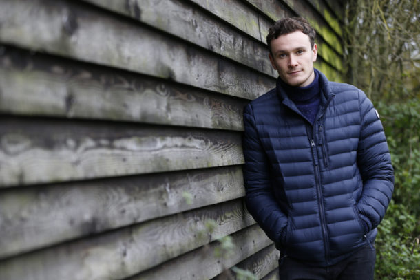 Outdoor Portrait Of Man Leaning Against Wooden Building